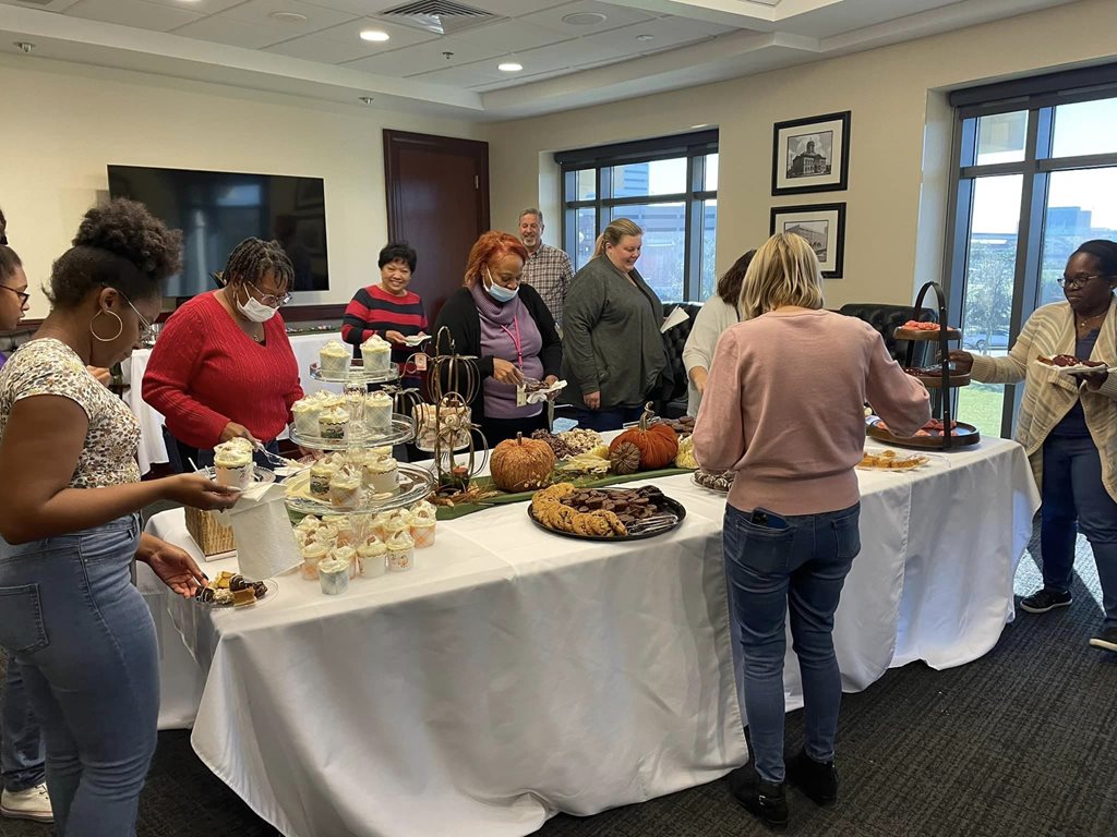 Clerk employees fill their plates to enjoy a dessert bar
